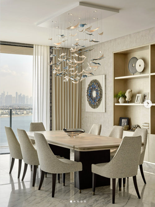 Chandelier for double‑height space, minimalist style for living and dining rooms, atmospheric artistic golden twisted‑leaf glass